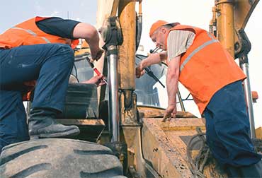 Two men repairing and excavator,
